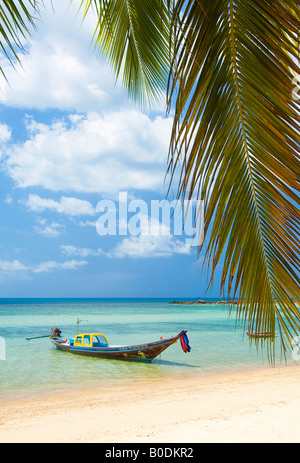 Un piccolo villaggio barca attende il suo proprietario come il mare giri sulle rive di questo paradiso tropicale Foto Stock