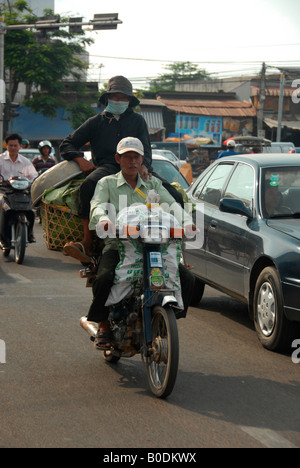 La gente per strada, equitazione sovraccaricato di motociclette, Phnom Penh Cambogia Foto Stock