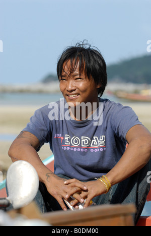 Un giovane pescatore tailandese gode di una pausa dal lavoro durante una calda giornata tropicale, Ko Phangan, Thailandia. Foto Stock