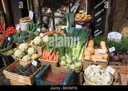 Scatole di verdure colorate al di fuori di un fruttivendolo shop nel villaggio Costwold di Broadway, si vende un sacco di prodotti locali. Foto Stock