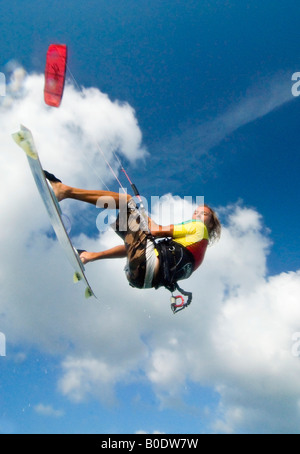 Una superiore tacca kite surfer ottiene qualche tempo aria come egli vola fuori di una forma d'onda Foto Stock