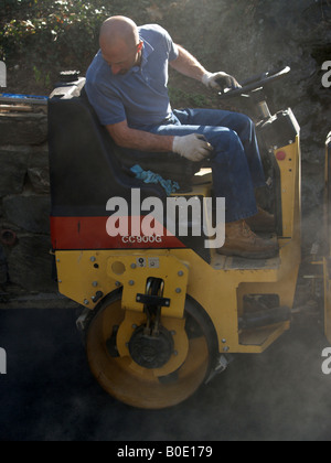 Workman panini freschi su asfalto appena costruito passo carraio Foto Stock