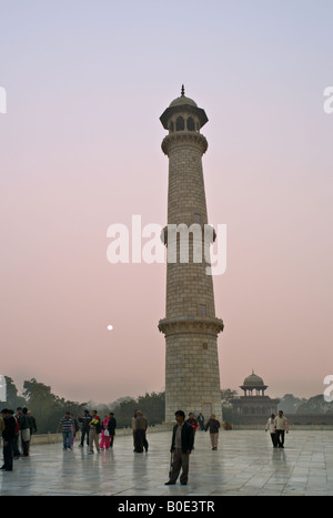 INDIA AGRA uno dei minarettes al monumento del Taj Mahal si vede attraverso la nebbia di mattina a sunrise come turisti indiano tour Foto Stock