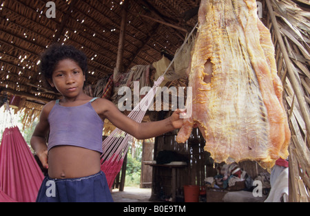 Ragazza giovane con un filetto affumicato da un pesce piraracu (seconda più grande pesce di acqua dolce sulla terra) Amaonon foresta pluviale del Brasile Foto Stock