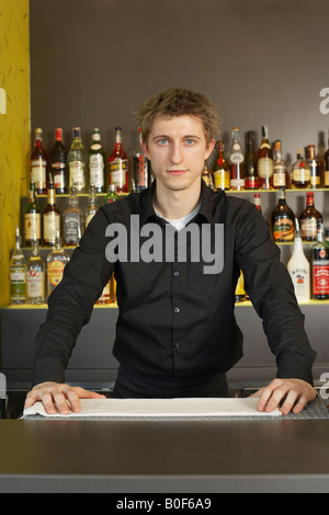 Ritratto di giovane barista dietro il suo bar Foto Stock