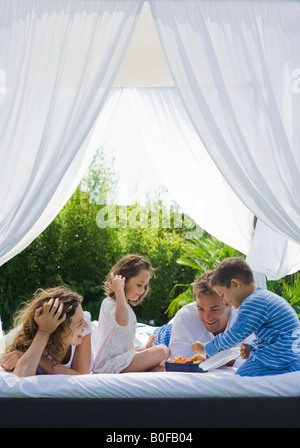 Famiglia con colazione a letto in giardino Foto Stock