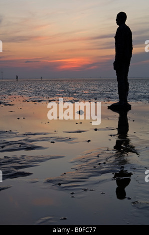 Antony Gormley è un altro posto statue al tramonto sulla spiaggia Crosby, Crosby, Merseyside England, Regno Unito Foto Stock