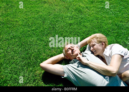 L uomo e la donna sdraiata su erba insieme Foto Stock
