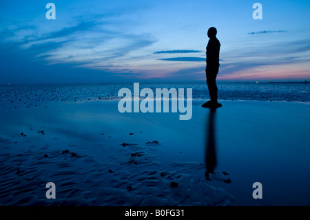 Antony Gormley è un altro posto statue al crepuscolo su Crosby Beach, Crosby, Merseyside England, Regno Unito Foto Stock