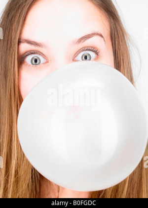 Donna che soffia su un bubble gum Foto Stock