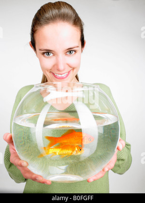 Donna che consegna a un goldfish aquarium Foto Stock