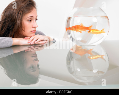 Donna che guarda un goldfish Foto Stock