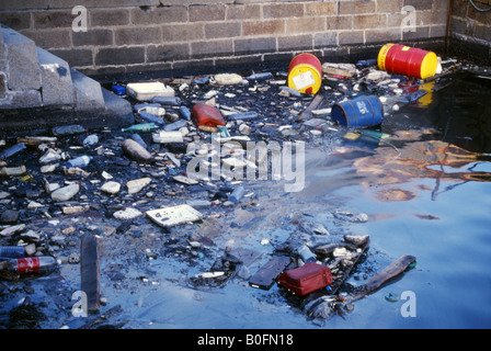 Tamburi di petrolio scartati e spazzatura inquinano l'acqua nel porto di Portsmouth Inghilterra Regno Unito Foto Stock