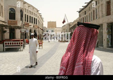 Gli uomini in abito tradizionale passeggiando attraverso il souq Waqif market a Doha, in Qatar. Foto Stock