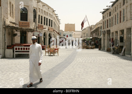 Gli uomini in abito tradizionale passeggiando attraverso il souq Waqif market a Doha, in Qatar. Foto Stock