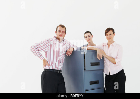 Tre uomini di affari che poggiano su cabinet Foto Stock