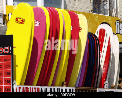 Una fila di tavole da surf a noleggio, Newquay Cornwall, Regno Unito Foto Stock