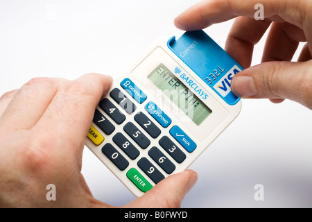 Inserimento di una scheda di addebito in un Barclays Bank Pin Sentry debit card reader Foto Stock