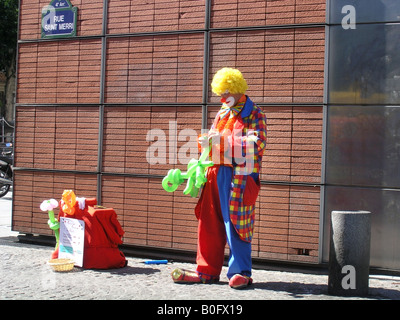 Clown solitaria la preparazione per il suo atto di palloncino in Rue St Merri 4° arr. Parigi Francia Foto Stock