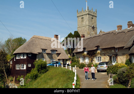 I turisti in visita a cottage con il tetto di paglia e chiesa a Godshill Isola di Wight in Inghilterra Foto Stock