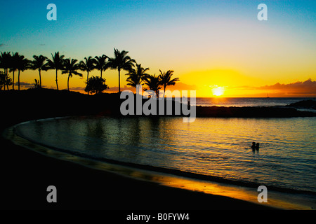 Coppia romantica baciare in una laguna su Oahu, Hawaii, durante un bel tramonto Foto Stock