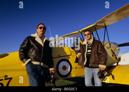 Due piloti con battenti giacche vicino al vecchio biplano trainer De Havilland DH 82c Tiger Moth Foto Stock