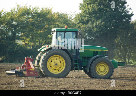 Trattore John Deere per la frangitura di zolle di un campo, Suffolk Foto Stock