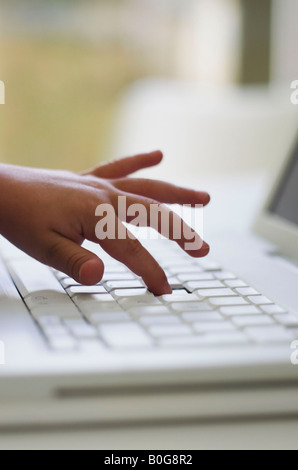 In prossimità del bambino la mano sul computer portatile Foto Stock