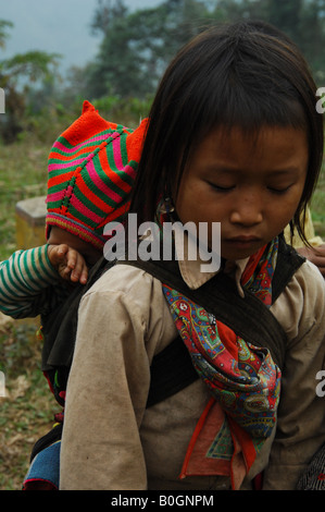 Giovane fiore ragazza hmong cercando dopo il suo fratellino, bac ha, vicino a sapa Foto Stock