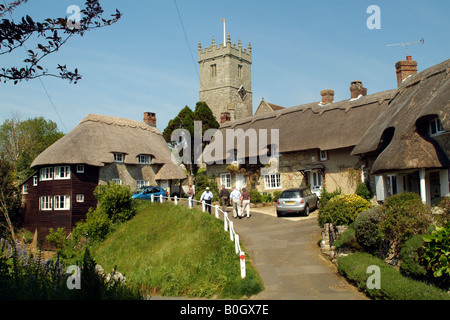 I turisti in visita a cottage con il tetto di paglia e chiesa a Godshill Isola di Wight in Inghilterra Foto Stock