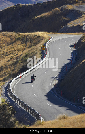 La motocicletta e S piegare Crown Range Road tra Queenstown e Wanaka Isola del Sud della Nuova Zelanda Foto Stock