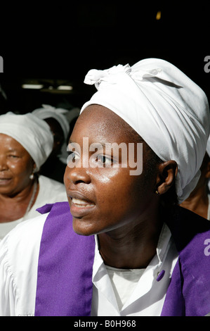 Donna vestita di bianco con anta viola in un servizio di chiesa a Douala Camerun, Africa Foto Stock