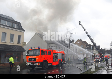 I vigili del fuoco nella lotta contro un incendio del tetto usando tubi flessibili di alta pressione e di una scala mobile in Bergisch Gladbach, Renania settentrionale-Vestfalia, G Foto Stock