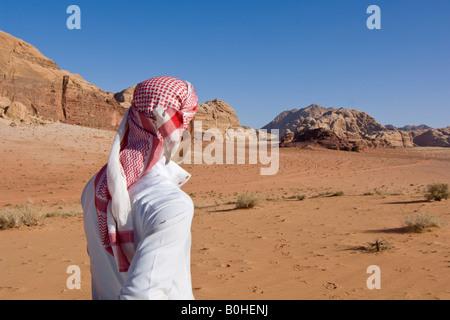 Bedouin guardando fuori nella distanza nel deserto, Wadi Rum, Giordania, Medio Oriente Foto Stock