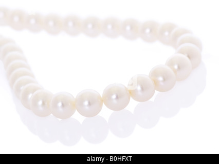 Collana di perle con la riflessione su sfondo bianco Foto Stock