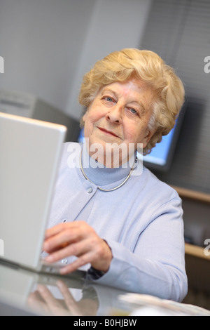 Vecchia donna, senior lavorando su un computer portatile Foto Stock