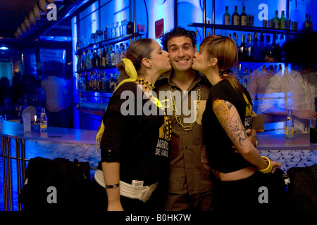 Due ragazze baciando un grinning uomo nel Deja Vu nightclub, Saragozza, Saragozza, Aragona, Spagna Foto Stock