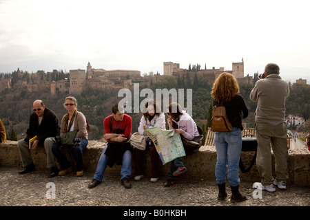 Tourist godendo della vista di Moorish Alhambra Palace Dal Mirador San Nicolas in El Albayzín o quartiere Albaicín di Foto Stock