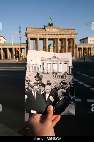 Di allora e di oggi, mano che tiene una foto in bianco e nero di Konrad Adenauer, di fronte al Brandenburger Tor o Porta di Brandeburgo, Foto Stock