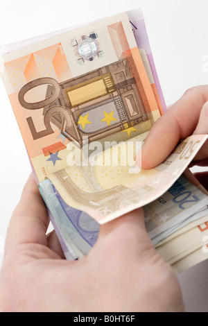 Mani tenendo le banconote in euro, bollette, contanti, conteggio di denaro Foto Stock