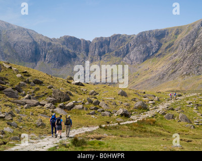 Gli escursionisti trekking sul Sentiero di Cwm Idwal con Devil's Kitchen (Twll Du) oltre nel Parco Nazionale di Snowdonia, Ogwen, Galles del Nord, Regno Unito Foto Stock