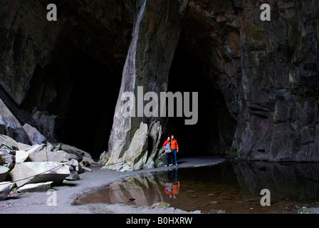 Due escursionisti maschio nella caverna della Cattedrale, una vecchia cava di ardesia in poco Langdale, Parco Nazionale del Distretto dei Laghi, Cumbria, England Regno Unito Foto Stock