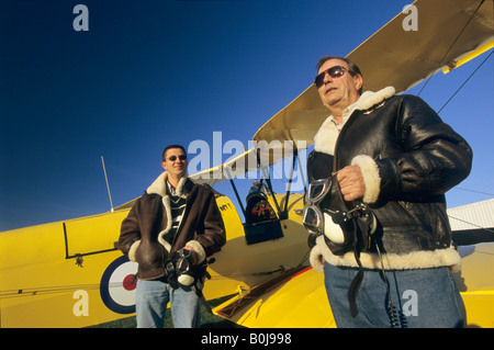 Due piloti con battenti giacche vicino al vecchio biplano trainer De Havilland DH 82c Tiger Moth Foto Stock