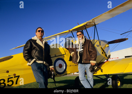 Due piloti con battenti giacche vicino al vecchio biplano trainer De Havilland DH 82c Tiger Moth Foto Stock