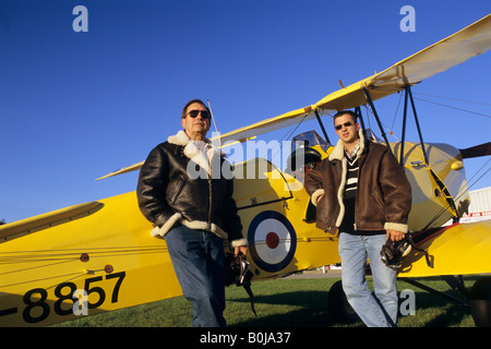 Due piloti con battenti giacche vicino al vecchio biplano trainer De Havilland DH 82c Tiger Moth Foto Stock