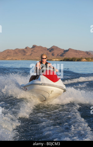 Giovane uomo che cavalca jetski sul lago Foto Stock