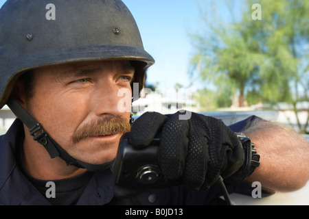 Swat officer utilizzando un walkie-talkie Foto Stock