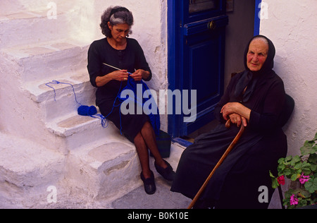 Due donna anziana madre e nonna al di fuori seduta di fronte porta Mykonos Grecia Foto Stock