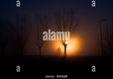 Ciclista durante il sorgere del sole Foto Stock