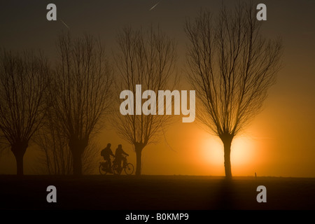 I ciclisti durante il sorgere del sole Foto Stock